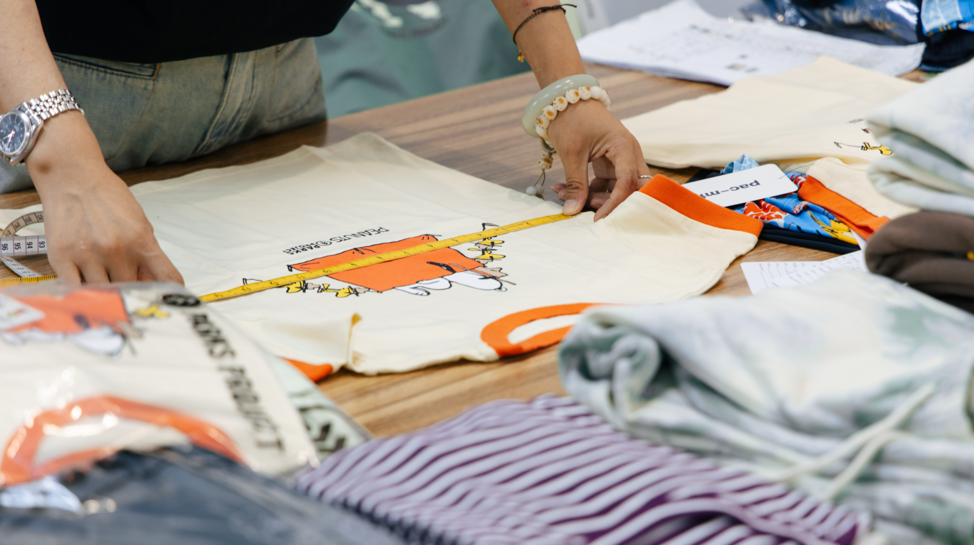 Quality control in T-shirt manufacturing - lady measuring shirt dimensions